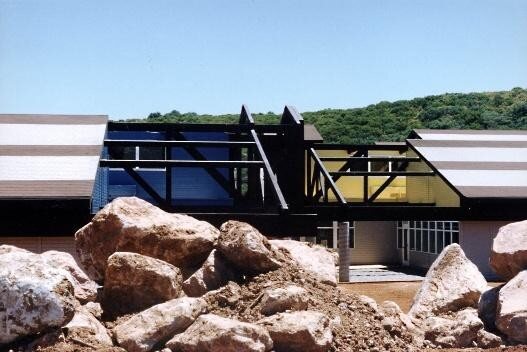 Classroom pavilions beyond a rock garden